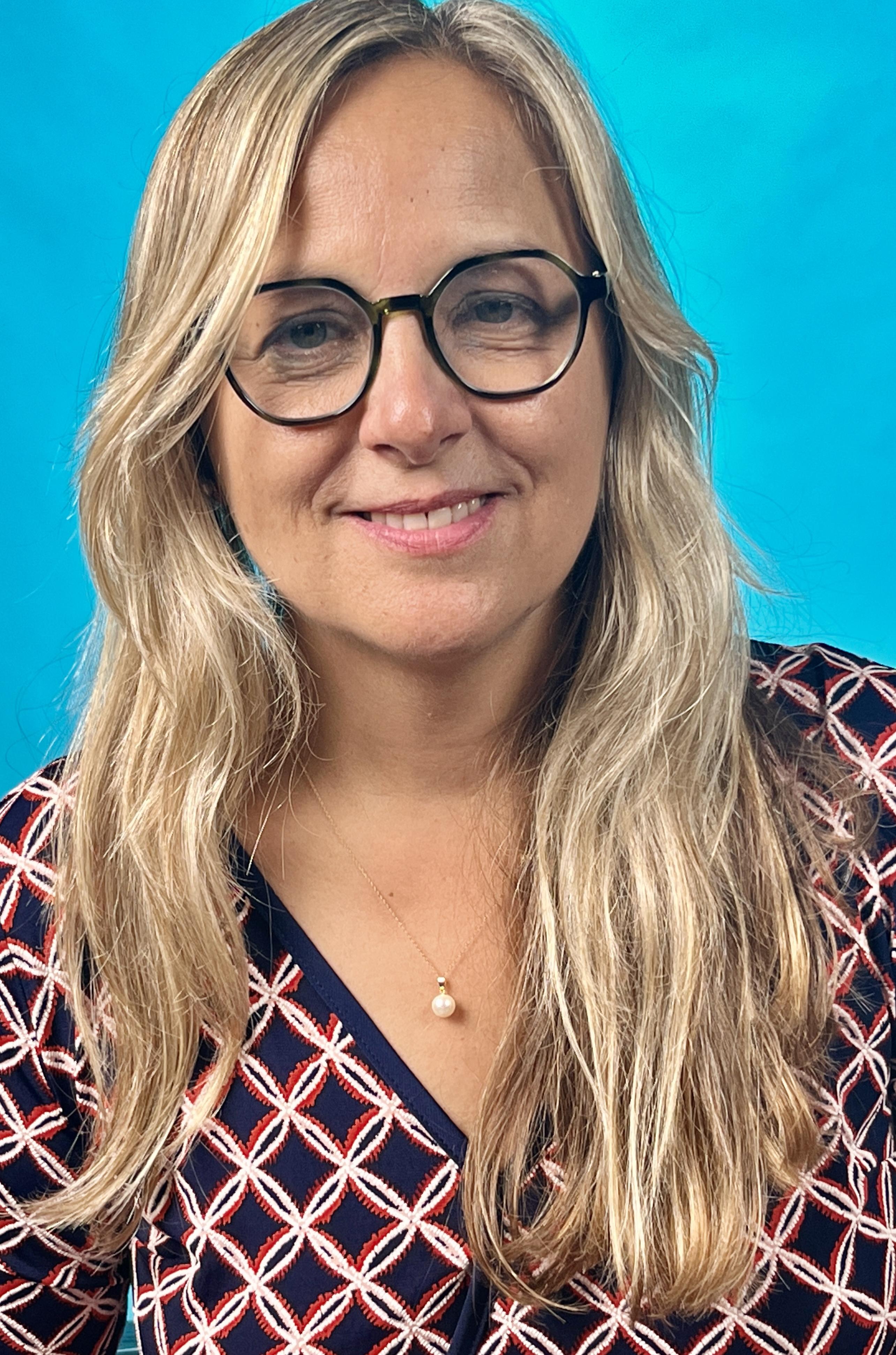 Dr. Canete wearing glasses with a sky blue background